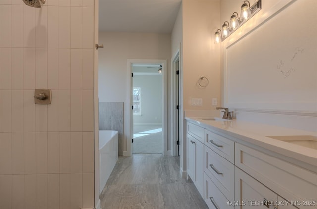 bathroom featuring a bathing tub, tile walls, and vanity