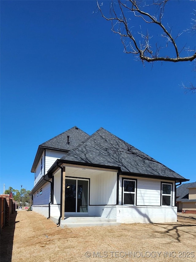 back of house with roof with shingles and fence