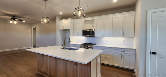 kitchen featuring visible vents, a sink, dark wood-style floors, white cabinetry, and stainless steel appliances