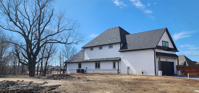 back of property featuring central air condition unit, a garage, and brick siding