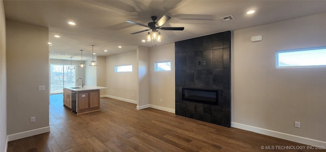 unfurnished living room with recessed lighting, baseboards, a ceiling fan, dark wood finished floors, and a large fireplace
