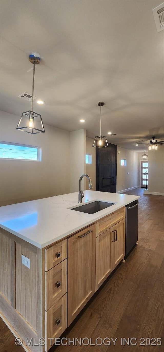 kitchen featuring light brown cabinets, dark wood-type flooring, dishwasher, pendant lighting, and a sink