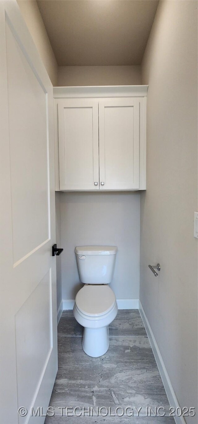 bathroom featuring wood finished floors, toilet, and baseboards