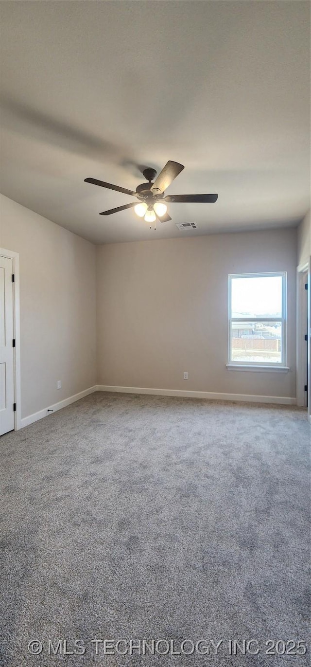 carpeted spare room with visible vents, ceiling fan, and baseboards