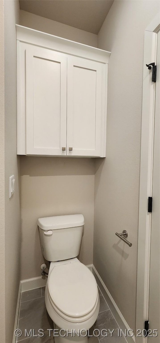 bathroom featuring toilet and baseboards