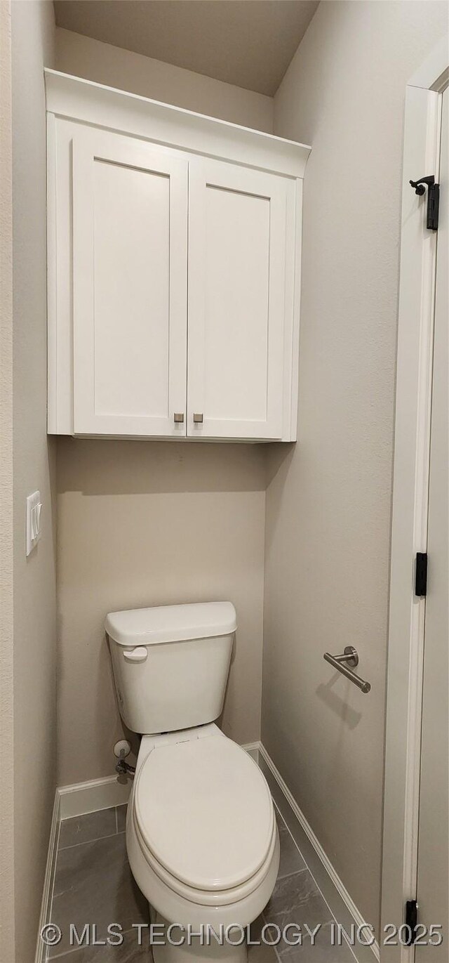 bathroom featuring baseboards and toilet