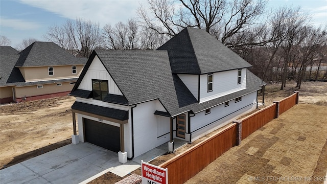 view of front of property featuring board and batten siding, driveway, and roof with shingles