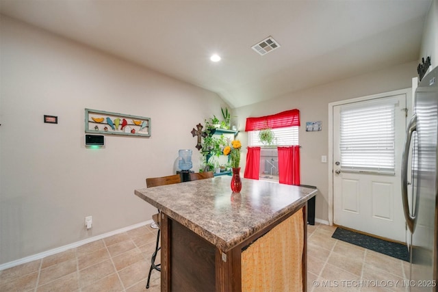 23260 Bessie Blvd, Claremore, OK 74019 - kitchen featuring a kitchen island, freestanding refrigerator, baseboards, recessed lighting, and a kitchen bar
