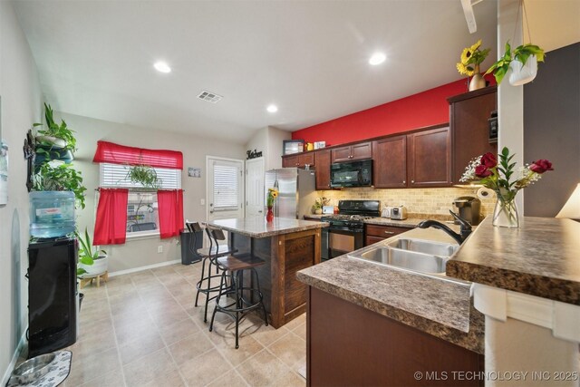 23260 Bessie Blvd, Claremore, OK 74019 - kitchen featuring black appliances, tasteful backsplash, a breakfast bar, a sink, and a kitchen island