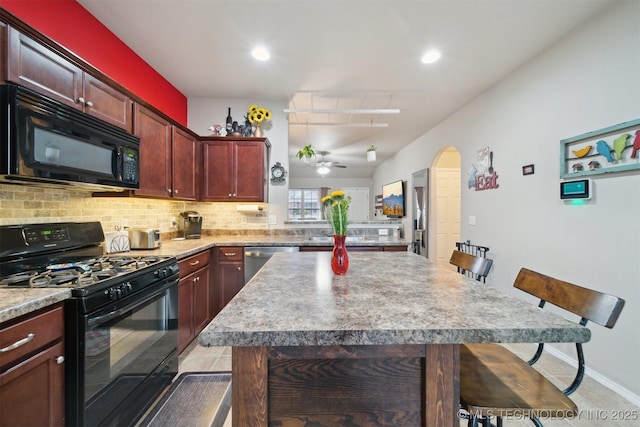 23260 Bessie Blvd, Claremore, OK 74019 - kitchen with black appliances, a breakfast bar area, ceiling fan, tasteful backsplash, and recessed lighting