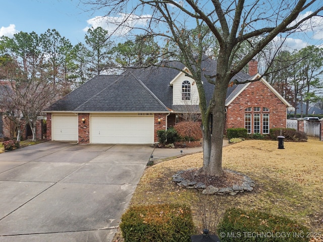 traditional home with fence, an attached garage, brick siding, a chimney, and concrete driveway