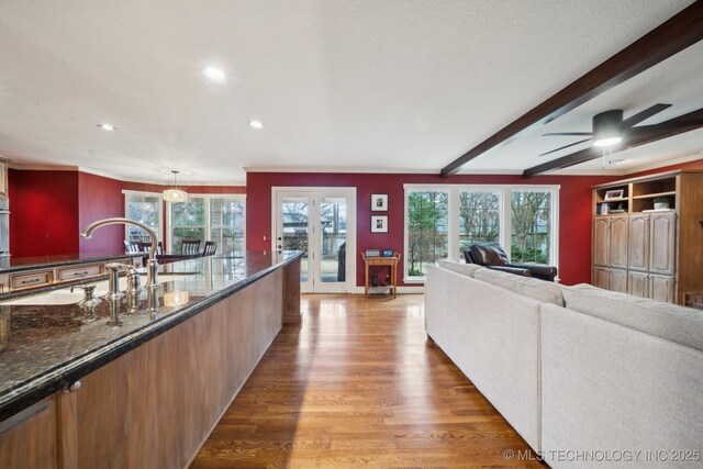 kitchen with hardwood / wood-style flooring, ceiling fan, and beam ceiling