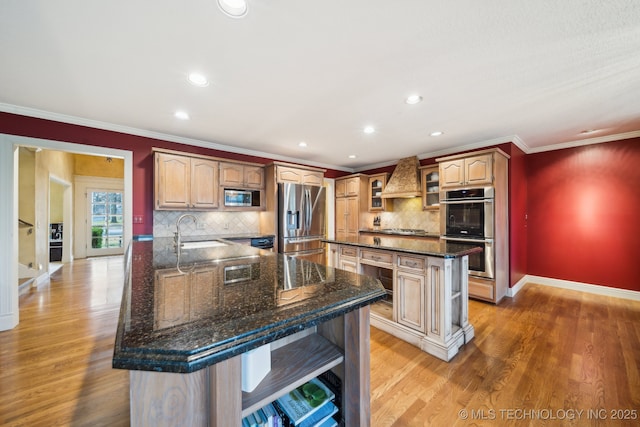 kitchen with appliances with stainless steel finishes, a breakfast bar, dark stone countertops, a center island, and crown molding