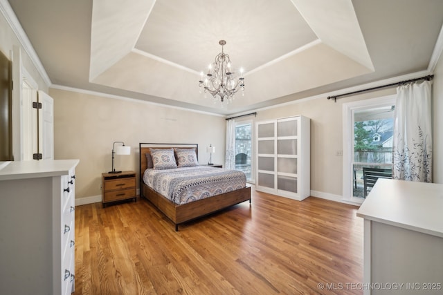 bedroom with crown molding, a tray ceiling, and hardwood / wood-style flooring