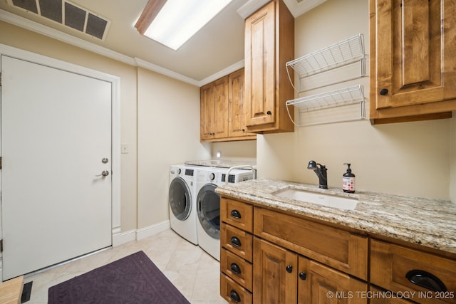 laundry room with washer and dryer, ornamental molding, sink, and cabinets