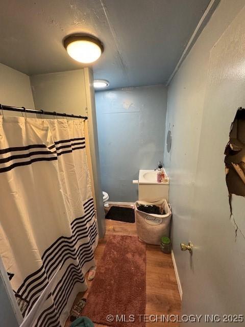 bathroom with hardwood / wood-style flooring and toilet