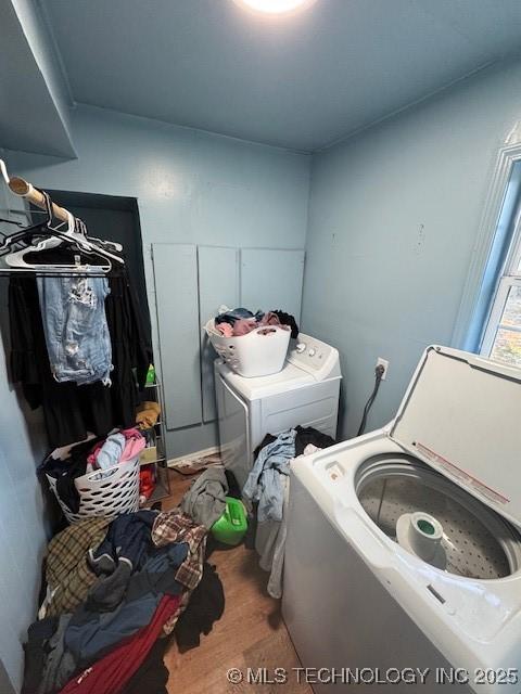 clothes washing area featuring hardwood / wood-style flooring and washer and clothes dryer