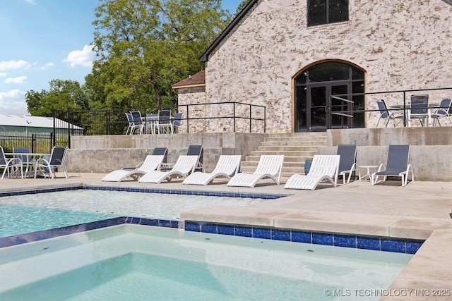 view of pool with an in ground hot tub and a patio