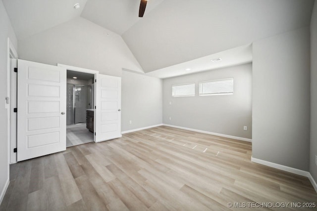 unfurnished bedroom featuring ceiling fan, ensuite bath, high vaulted ceiling, and light wood-type flooring