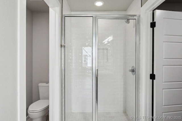 bathroom with toilet and an enclosed shower