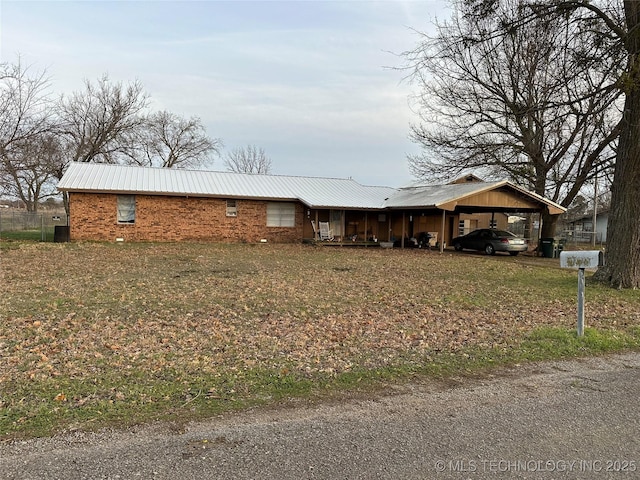 view of front of home with a carport and a front lawn