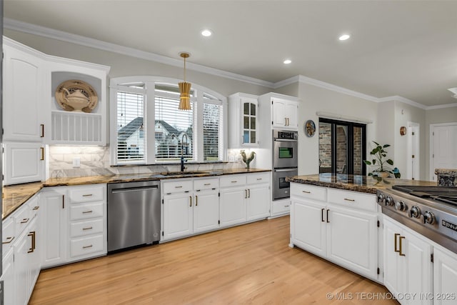 kitchen featuring stainless steel appliances, sink, white cabinets, and dark stone counters