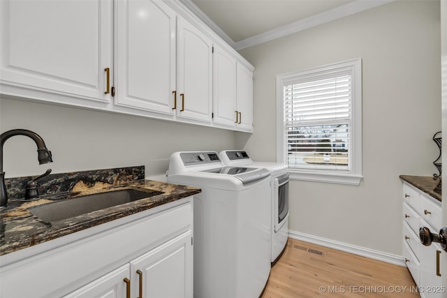 laundry room with washer and dryer, sink, cabinets, ornamental molding, and light hardwood / wood-style floors