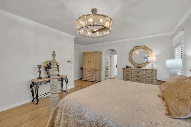 bedroom featuring light wood-type flooring, crown molding, arched walkways, and a notable chandelier