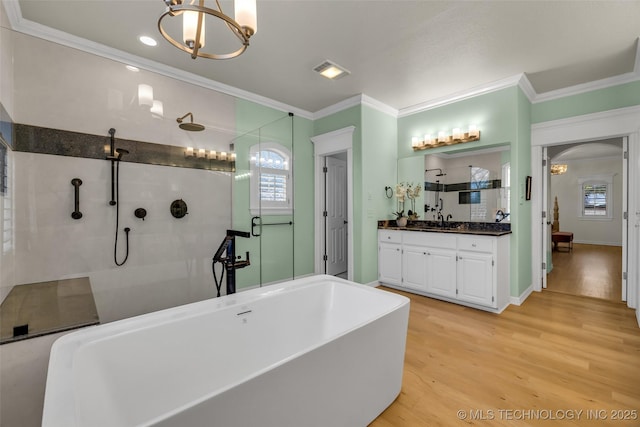 bathroom with vanity, crown molding, wood-type flooring, and separate shower and tub