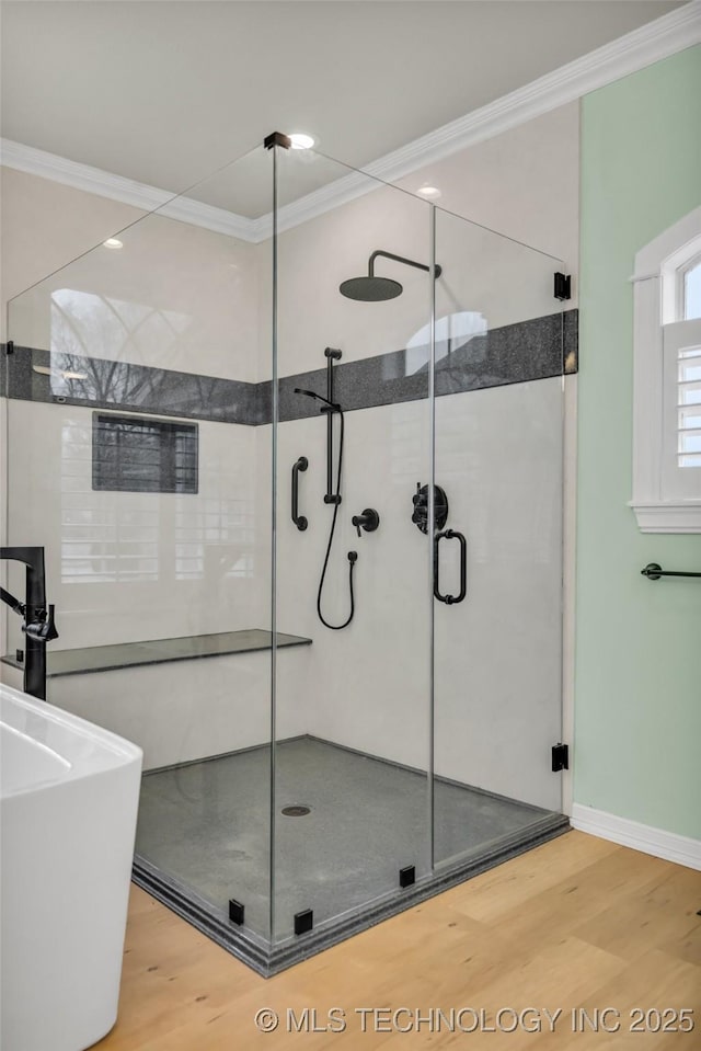 bathroom with hardwood / wood-style flooring, ornamental molding, and separate shower and tub