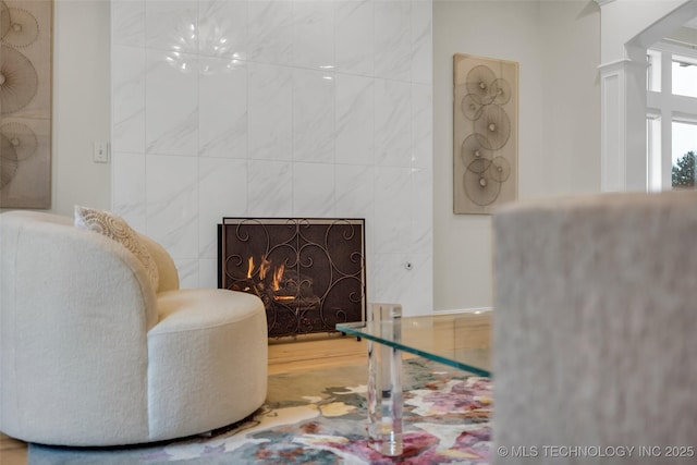 sitting room with a fireplace and decorative columns