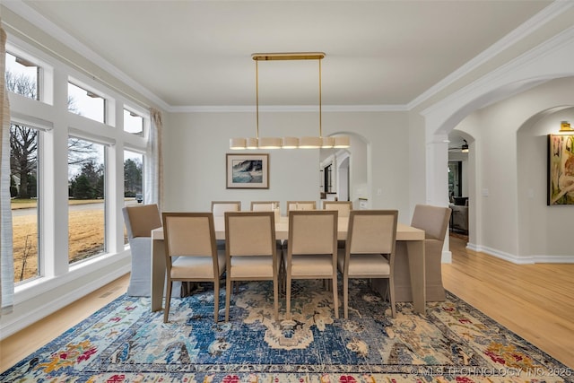 dining area with ornamental molding and hardwood / wood-style floors