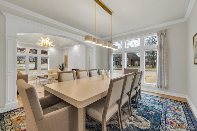 dining room with ornamental molding, a healthy amount of sunlight, and a chandelier