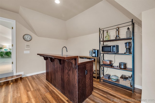 bar with hardwood / wood-style flooring and vaulted ceiling