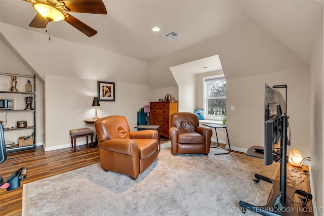 sitting room with vaulted ceiling, wood finished floors, visible vents, and baseboards