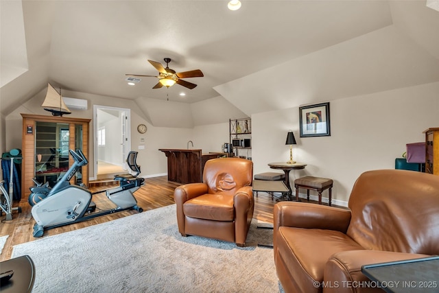 sitting room featuring ceiling fan, lofted ceiling, a wall unit AC, and light hardwood / wood-style floors