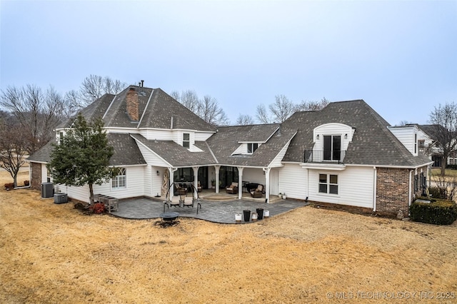 rear view of house with a patio, a yard, and central AC