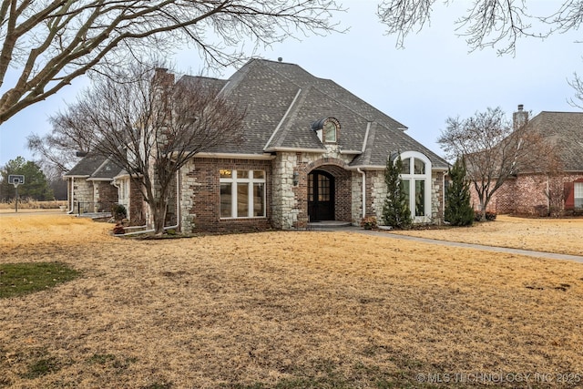 french country inspired facade featuring a front yard