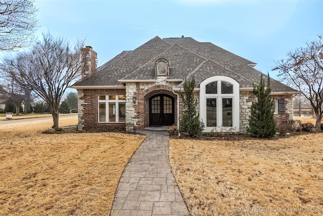 view of front facade with french doors and a front lawn