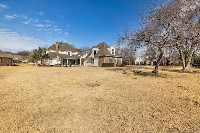 rear view of house with a yard and brick siding