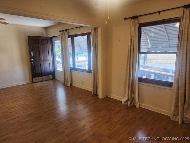 foyer with ceiling fan, baseboards, and dark wood-style flooring