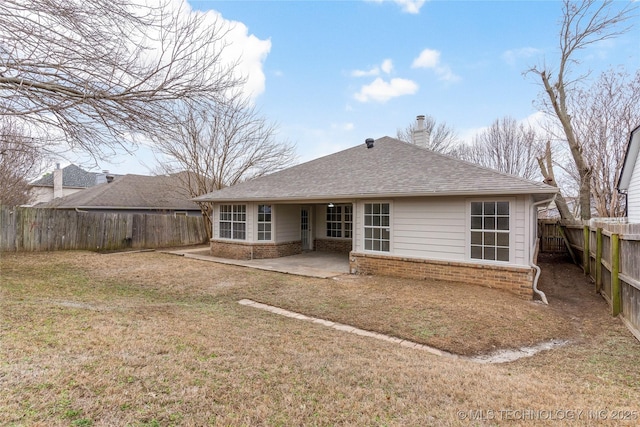 back of property with a lawn and a patio