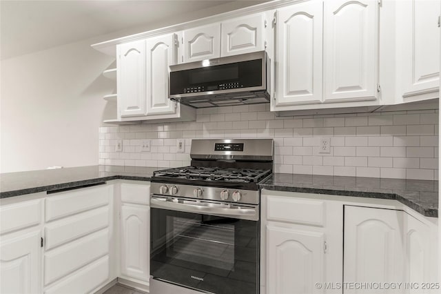 kitchen featuring dark stone countertops, appliances with stainless steel finishes, decorative backsplash, and white cabinets