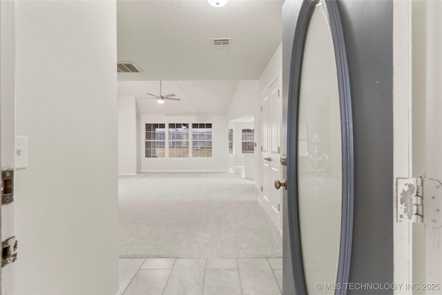 corridor featuring light carpet and a textured ceiling