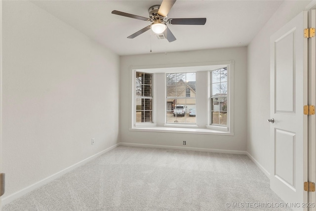 empty room featuring light colored carpet and ceiling fan