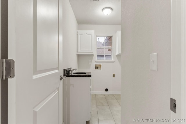 laundry room with sink, cabinets, washer hookup, light tile patterned floors, and electric dryer hookup