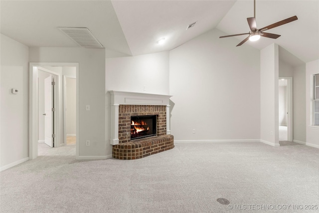 unfurnished living room with lofted ceiling, a brick fireplace, light colored carpet, and ceiling fan