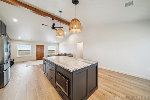 kitchen featuring appliances with stainless steel finishes, vaulted ceiling with beams, hanging light fixtures, light stone counters, and light hardwood / wood-style flooring