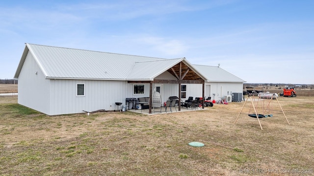 rear view of house with a patio, a lawn, and central air condition unit