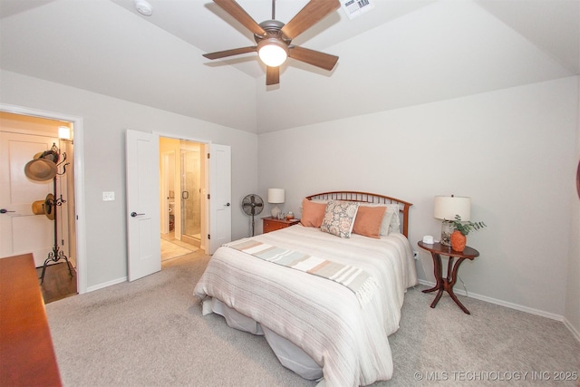 carpeted bedroom with ceiling fan, vaulted ceiling, and ensuite bath